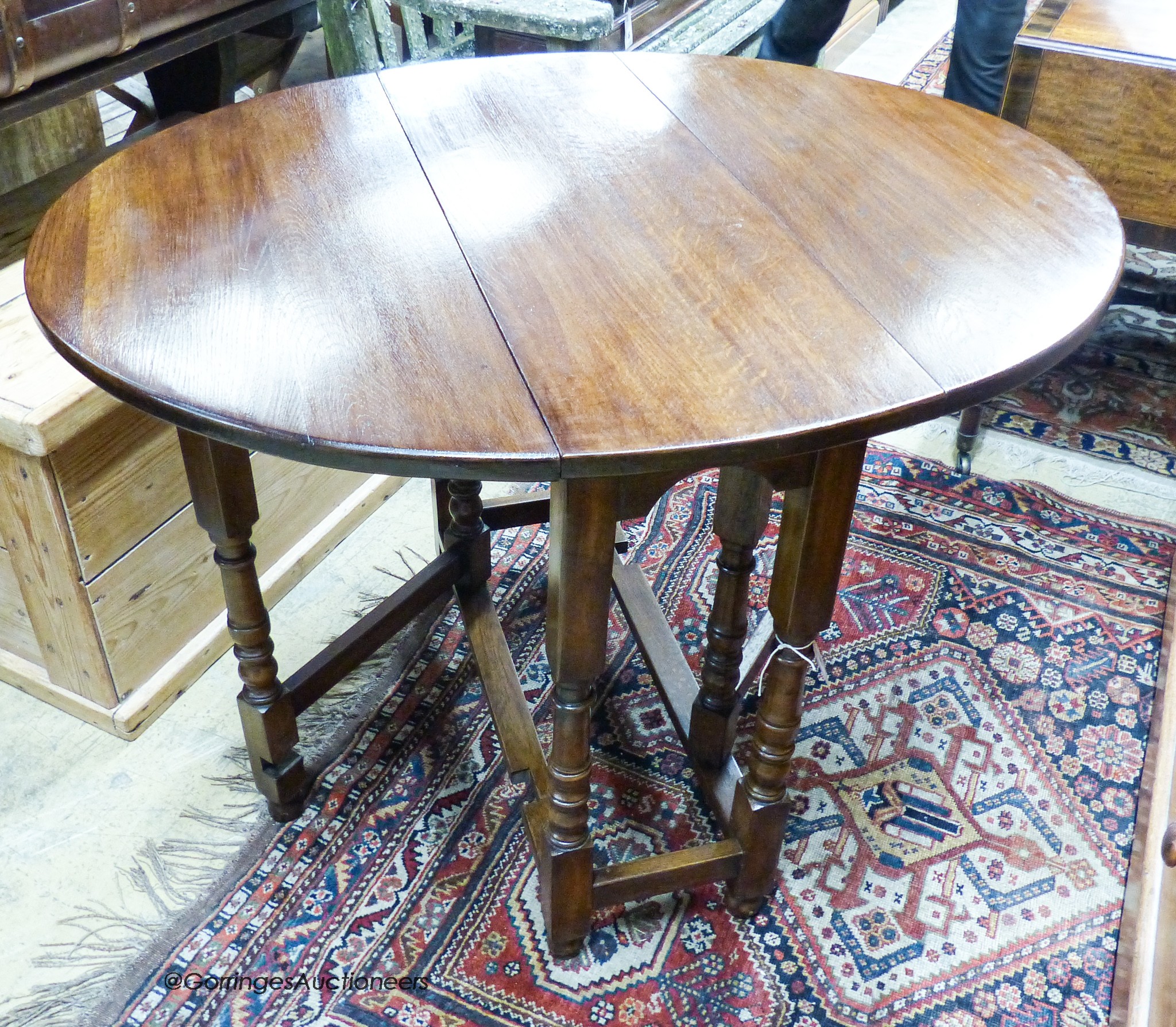 An 18th century style oval oak gateleg table, 100cm extended, depth 83cm, height 74cm
